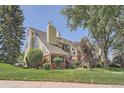 A multi-level condo building featuring brick and wood accents, set amidst a well-maintained lawn and mature trees at 13704 E Lehigh Ave # D, Aurora, CO 80014