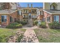 Multi-level condo building with balconies, brick accents, and a 'For Sale' sign indicating a listing opportunity at 13704 E Lehigh Ave # D, Aurora, CO 80014