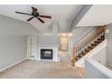 Inviting living room with a fireplace, open staircase, and a view into the next room at 9737 Canberra Ct, Highlands Ranch, CO 80130