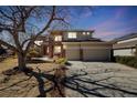 Charming two-story home with brick and siding, a three-car garage, and a landscaped front yard at 8941 Tuscany Ln, Highlands Ranch, CO 80130
