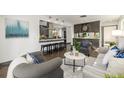 Open-concept living room with stylish seating, adjacent kitchen, and hardwood floors at 6490 E Dakota Ave, Denver, CO 80224