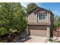 Exterior view of the home with a two-car garage and well-maintained landscaping at 2587 Foothills Canyon Ct, Highlands Ranch, CO 80129