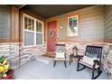 Cozy front porch with chairs, plants, stone accents, and a welcoming front door with wreath at 853 Stagecoach Dr, Lafayette, CO 80026