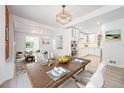 Elegant dining area featuring modern light fixture, wood table, and open view to the living room and kitchen at 2767 W 38Th Ave, Denver, CO 80211