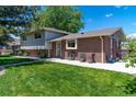 Exterior featuring brick and siding with lush green grass and manicured landscaping at 16225 W 74Th Dr, Arvada, CO 80007