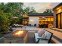 Backyard patio with stone fire pit, comfortable seating, dining table, and lush greenery at 5160 S Franklin St, Greenwood Village, CO 80121