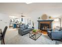 Bright living room with a cozy fireplace, skylight, and open layout, seamlessly connected to the kitchen and dining area at 247 Regal St, Louisville, CO 80027