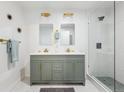 Well-lit bathroom featuring double sinks, sleek vanity, and glass-enclosed shower at 11842 W 14Th Ave, Lakewood, CO 80401