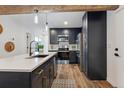 Modern kitchen with stainless appliances, an island, and beautiful wooden beam detail at 11842 W 14Th Ave, Lakewood, CO 80401