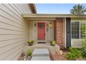 Inviting front entrance with a charming red door, brick accents, and well-maintained landscaping at 8441 S Timberwood St, Highlands Ranch, CO 80126