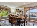 Traditional dining room featuring hardwood floors, a large mirror, and windows with backyard views at 8293 S Reed St, Littleton, CO 80128