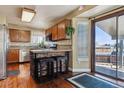 Eat-in kitchen featuring a bar area and a sliding glass door leading to the backyard at 8293 S Reed St, Littleton, CO 80128