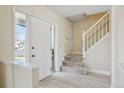 Bright foyer with white staircase, leading to the upper level of the house, and a door to enter the house at 5667 W 109Th Cir, Westminster, CO 80020