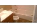 A compact bathroom with a wood vanity, toilet, and a tub with a shower at 10762 E Exposition Ave. Ave # 137, Aurora, CO 80012