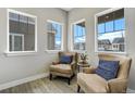 Cozy sitting area with two comfortable armchairs and ample natural light from windows at 16277 Talons Bluff Ln, Monument, CO 80132