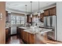 Kitchen with dark wood cabinets, granite countertops, stainless steel appliances, and an island at 869 Bluestem Ln, Louisville, CO 80027