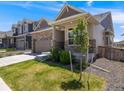 Well-kept single Gathering home with stone and siding exterior, green lawn, and mature landscaping at 16448 E 111Th Pl, Commerce City, CO 80022