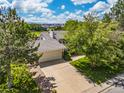 Aerial view of a home with a large driveway and lush landscaping on a sunny day at 1245 Ceres Dr, Lafayette, CO 80026