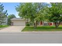 Charming home with a two-car garage, driveway, and lush green lawn at 1245 Ceres Dr, Lafayette, CO 80026