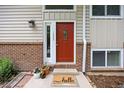 Inviting front door with brick accents, a decorative welcome mat, and potted plants at 1245 Ceres Dr, Lafayette, CO 80026