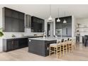 Stylish kitchen featuring dark cabinetry, quartz countertops, stainless steel appliances, and a center island at 5831 Galena St, Denver, CO 80238