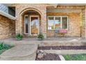 Inviting brick porch featuring an arched doorway, a cozy bench, and decorative planters at 5115 Bristol St, Arvada, CO 80002