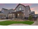 Charming home boasts a covered porch with stone pillars and lush green lawn at 11261 Moonshimmer St, Littleton, CO 80125