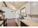 Bright kitchen with stainless steel sink, tile countertops and wood-look flooring at 671 Brentwood St, Lakewood, CO 80214