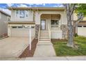 Two-story home featuring a covered front porch, stone accents, an attached garage, and fresh landscaping at 10626 Cherrybrook Cir, Highlands Ranch, CO 80126