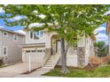 Inviting two-story home with a covered front porch, stone accents, attached garage, and mature tree in the yard at 10626 Cherrybrook Cir, Highlands Ranch, CO 80126