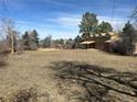 Very large backyard with patchy grass behind a two-story home at 5449 S Locust St, Greenwood Village, CO 80111