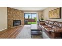 Inviting living room with stone fireplace, wood floors, and large sliding doors to the outside at 7474 E Arkansas Ave # 13-02, Denver, CO 80231