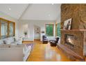 Bright living room with hardwood floors, a stone fireplace, and vaulted ceilings, creating a cozy and inviting atmosphere at 2398 Bitterroot Ln, Golden, CO 80401