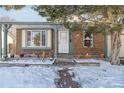 Brick home with front porch and snowy landscaping at 8478 Prairie Clover Way, Parker, CO 80134