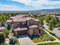 Stunning aerial view of a luxury home with a tiled roof, manicured landscaping, and mountain views at 2256 S Isabell Ct, Lakewood, CO 80228