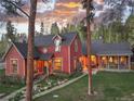 Inviting two-story red home with a covered porch, stone accents and well-maintained landscaping at 102 S High St, Breckenridge, CO 80424