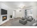 Bright living room features a brick fireplace, wood floors, and lots of natural light from large windows at 452 Black Feather Loop # 606, Castle Rock, CO 80104
