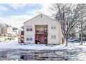Two-story condo featuring wood stairs, covered balconies, and a serene snowy landscape at 1128 S Ventura Cir # B, Aurora, CO 80017