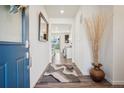 Bright entryway with wood floors, stylish rug, and view into the living area at 1123 Williams Loop, Elizabeth, CO 80107