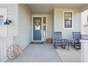 Inviting front porch with blue door, rocking chairs, and decorative wreath at 1123 Williams Loop, Elizabeth, CO 80107