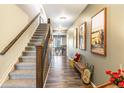 Inviting hallway with wood floors, a staircase, and decorative artwork with access to dining area at 42891 Hawktree Cir, Elizabeth, CO 80107
