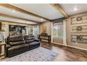 Cozy living room featuring wood beam ceilings, hardwood floors, and an open layout at 42891 Hawktree Cir, Elizabeth, CO 80107