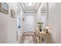 Bright entryway with wood-look floors, decorative rug and table; neutral walls at 11884 Barrentine Loop, Parker, CO 80138