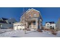 Two-story house with stone and siding, two-car garage, and snowy front yard at 1143 Williams Loop, Elizabeth, CO 80107