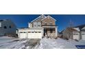 Two-story house with stone and siding, three-car garage, and snowy front yard at 1143 Williams Loop, Elizabeth, CO 80107