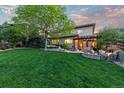 Expansive backyard with lush lawn, mature trees, and a cozy outdoor living space at 6874 Raspberry Run, Littleton, CO 80125