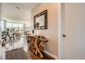 Hallway with a unique wood console table, decorative mirror, and views of the open-concept living area at 4200 W 17Th Ave # 611, Denver, CO 80204