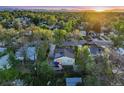 An aerial view of the home in a lush neighborhood with mature trees and mountain views in the distance at 2666 S Green Ct, Denver, CO 80219