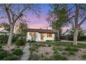 Charming single story home featuring beautiful landscaping with mature trees and flowering plants at 2666 S Green Ct, Denver, CO 80219