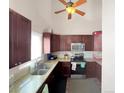 Well-equipped kitchen with dark cabinets, granite countertops, and stainless steel appliances under vaulted ceiling at 3782 S Genoa Cir # A, Aurora, CO 80013